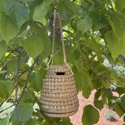 Ruche en paille suspendue dans le jardin