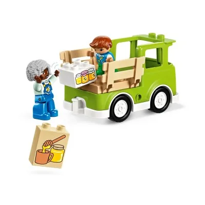 Figurines grand-mère et enfant chargeant le miel dans un camion vert – set LEGO DUPLO abeilles et ruches.
