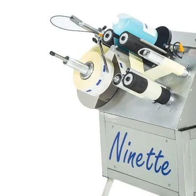 Machine d’étiquetage Ninette 1 CDA sur châssis inox à roulettes pour produits cylindriques