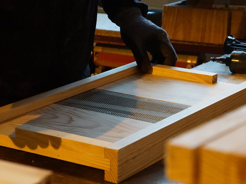 Un membre de l’équipe assemble un élément en bois dans l’atelier de menuiserie lors des portes ouvertes 2025