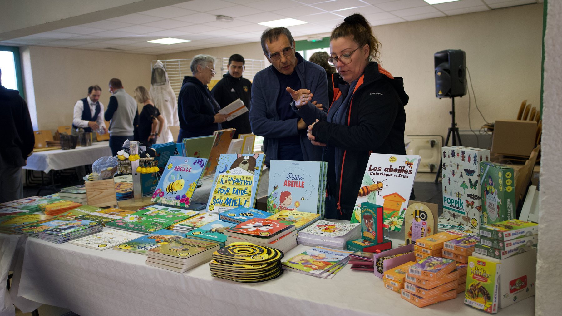 Des visiteurs échangent autour des livres apicoles au stand de la Foire au miel de Castres 2024